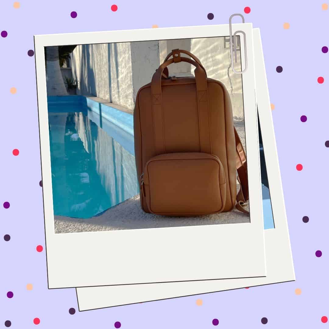 Cover image for the Monos Metro backpack review. Features a purple background with pink and purple dots on it and a polaroid photo frame with a photo of the backpack inside it.