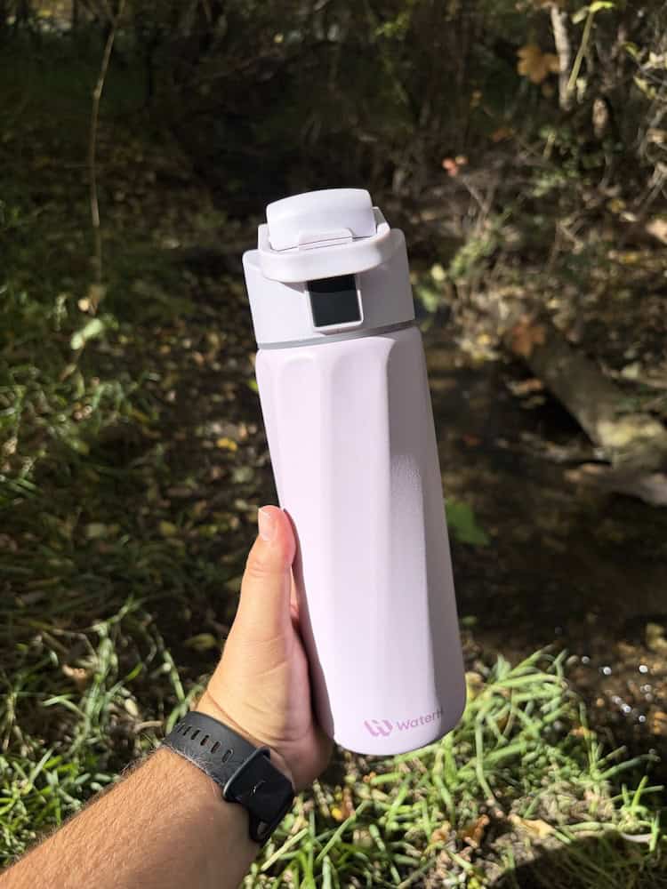A picture of a hand holding the WaterH smart water bottle.