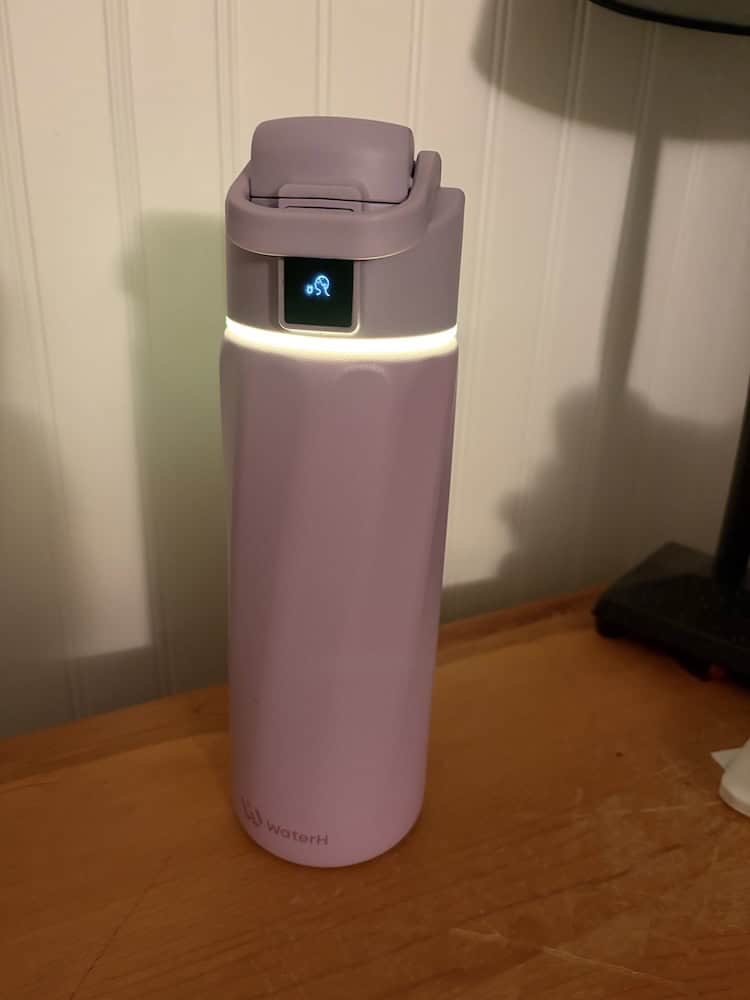 Image of the WaterH smart bottle with the ring lit up indicating for you to drink from it.